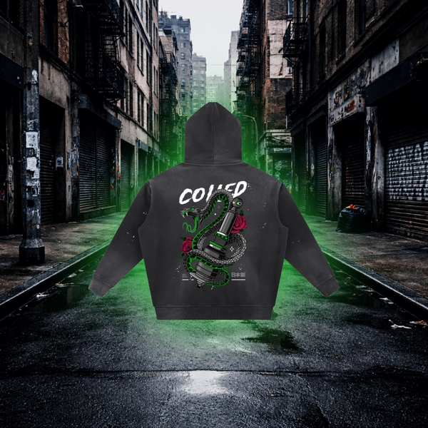 Black hoodie with graphic design and text on a neon green-lit urban street. Coiled Snake Graphic Hoodie – Premium Streetwear Animal Design Hoodie