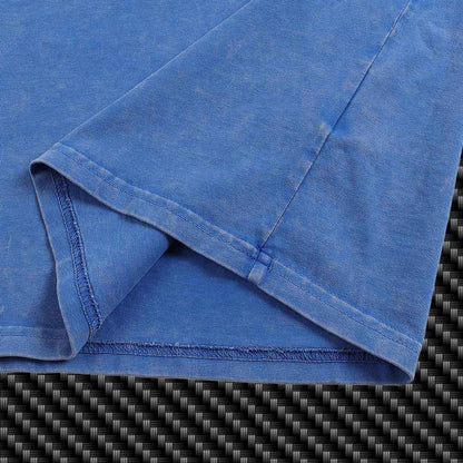 Folded blue fabric of a Premium T-Shirt on a carbon fiber background