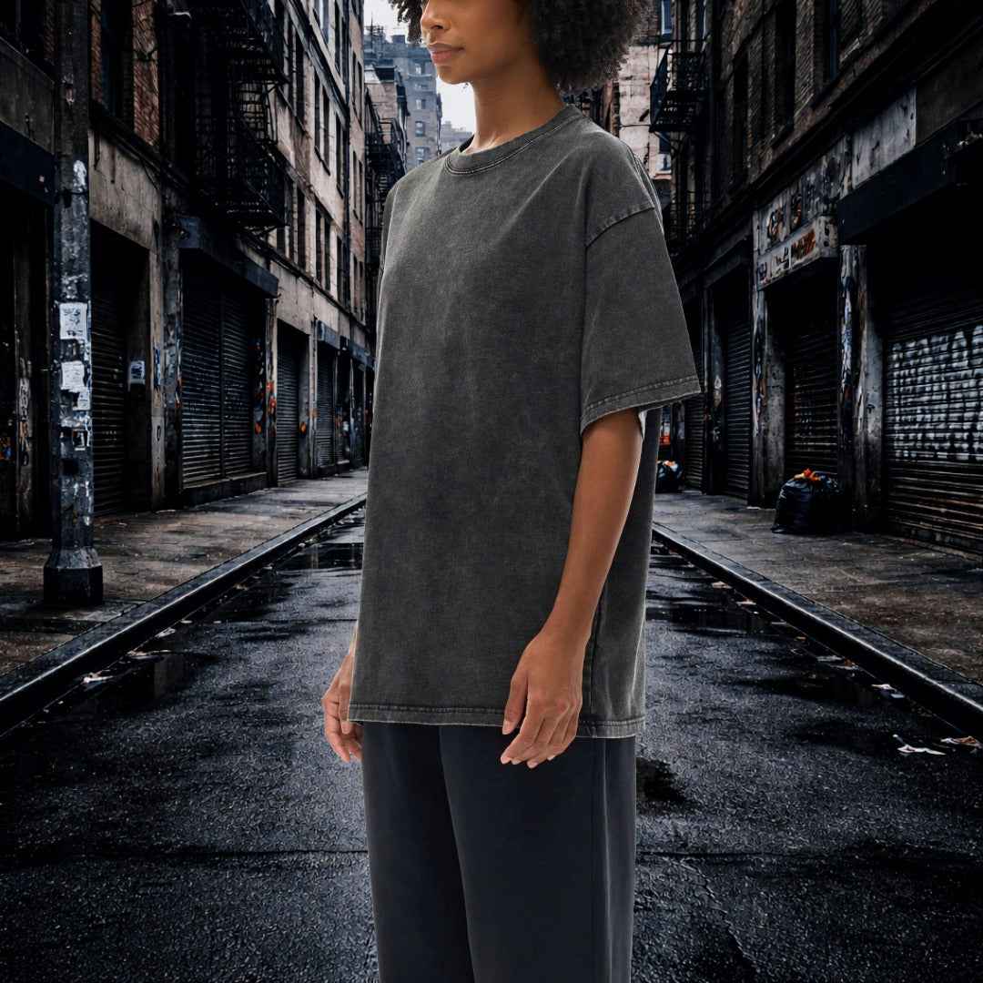 Person wearing a gray t-shirt standing in an urban alleyway.