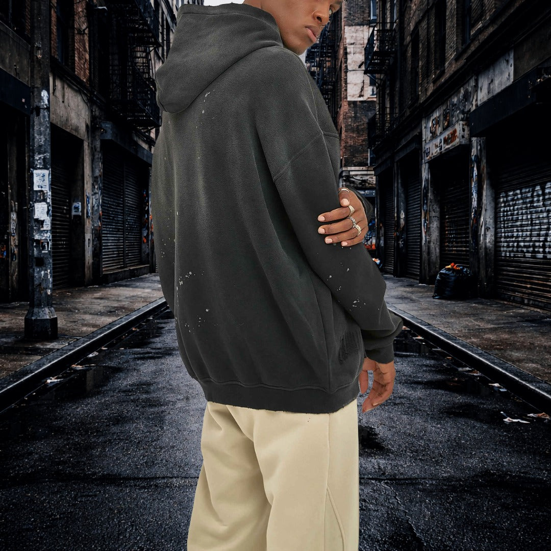 Person wearing a dark hoodie and light pants standing in an urban alleyway. Samurai Street Beast Oversized Hoodie – Power Drift Car Streetwear Hoodie